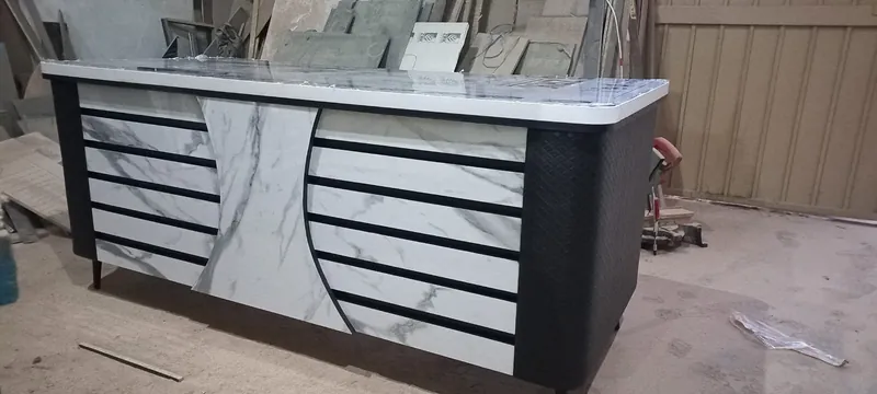 Reception counter in white marble finish with black slats